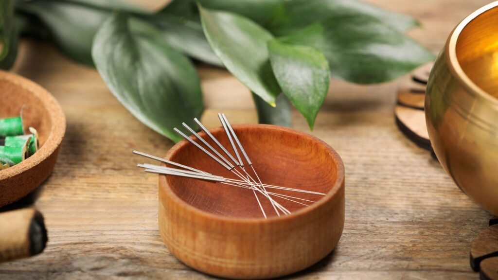 Agujas de acupuntura en un cuenco de madera para tratamientos de medicina china