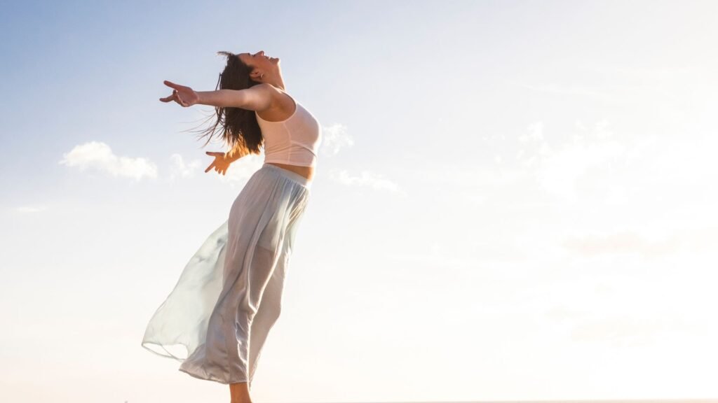 Mujer feliz saltando tras un proceso de bienestar con terapias orientales y energéticas en Barcelona